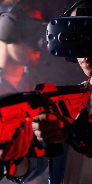 Portrait of woman playing virtual game with his boyfriend, hold vr guns and wearing special heasedts. Digital, hi-tech